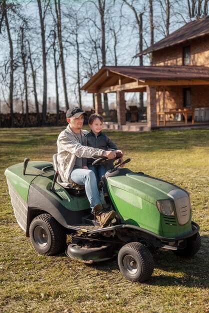 Full shot smiley man driving lawn mower