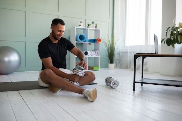 Full shot smiley man holding dumbbell