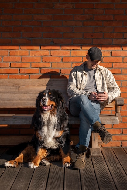 Free photo full shot smiley man holding smartphone