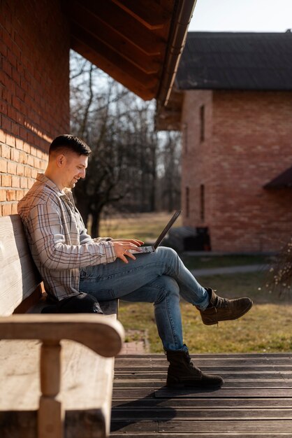 Full shot smiley man using laptop