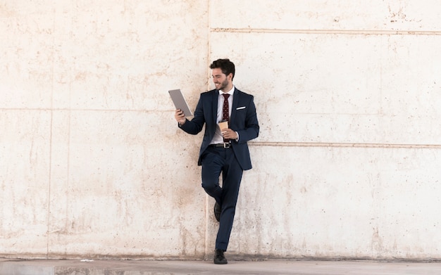 Full shot smiley man with tablet and coffee