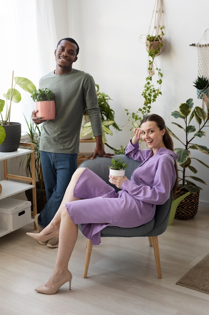 Full shot smiley man and woman with plants