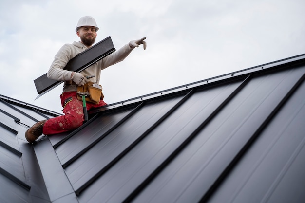 Free photo full shot smiley man working on roof