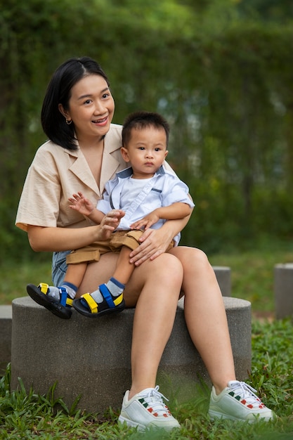 Full shot smiley mother holding boy