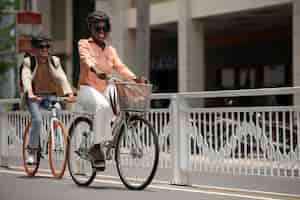 Free photo full shot smiley people on bicycles