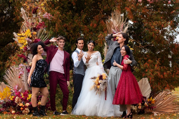 Free photo full shot smiley people posing at wedding