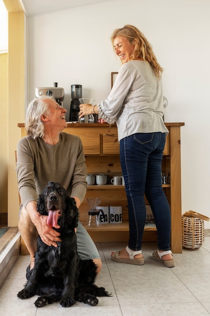 Free photo full shot smiley people with dog at home