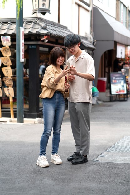 Full shot smiley people with smartphone