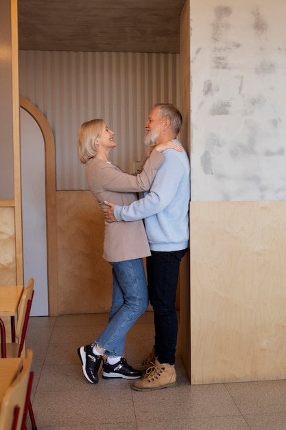 Free photo full shot smiley senior couple indoors