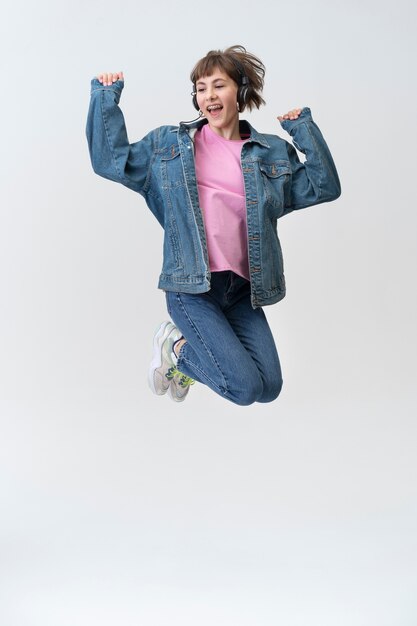 Full shot smiley teenager jumping