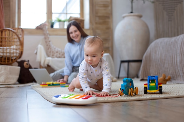 Free photo full shot smiley woman and baby on floor