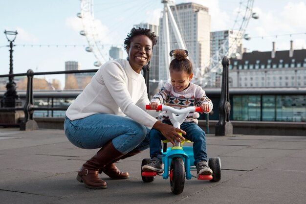 Full shot smiley woman and child on tricycle