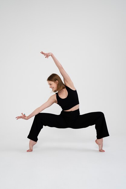 Full shot smiley woman dancing in studio