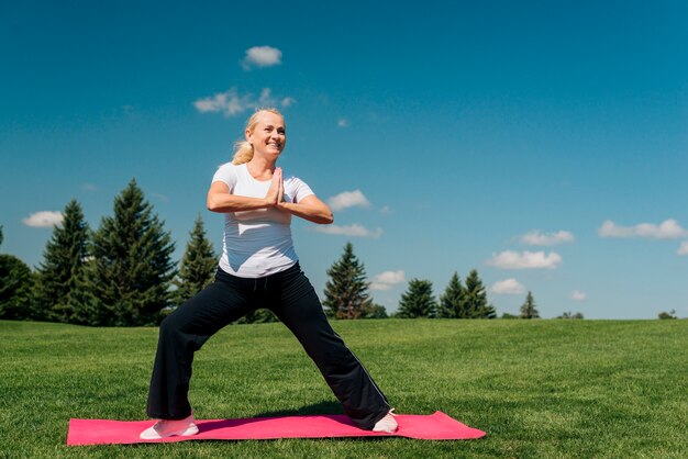 Full shot smiley woman exercising outdoors