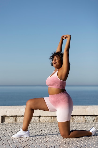 Full shot smiley woman exercising outdoors