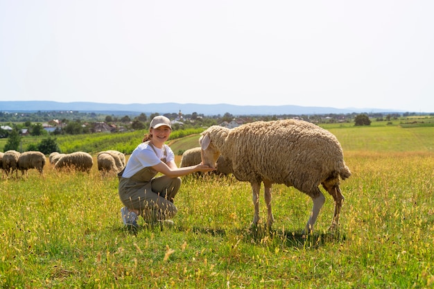 Full shot smiley woman feeding sheep