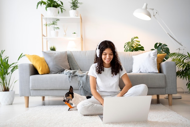 Full shot smiley woman on floor with laptop