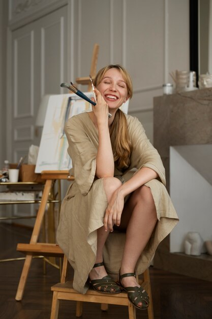 Full shot smiley woman holding brushes