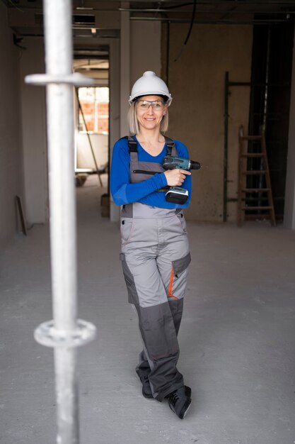 Full shot smiley woman holding drill