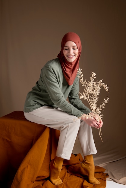 Free photo full shot smiley woman holding plants