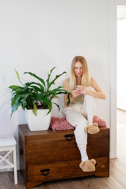 Full shot smiley woman holding smartphone