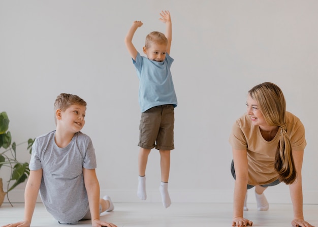 Free photo full shot smiley woman and kids