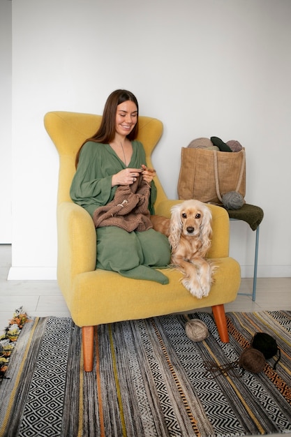 Full shot smiley woman knitting