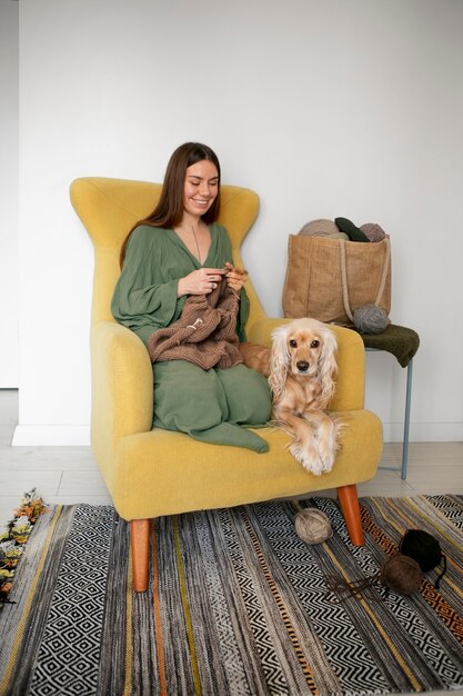 Full shot smiley woman knitting