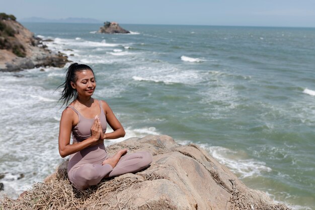 Full shot smiley woman meditating outdoors