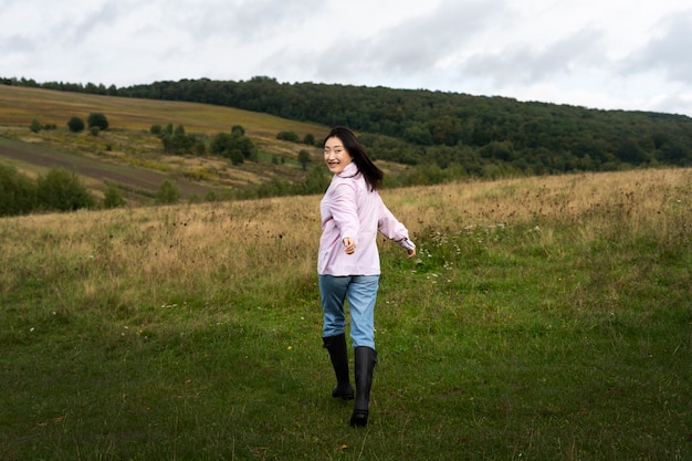 Free photo full shot smiley woman outdoors