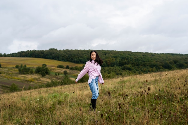 Free photo full shot smiley woman outdoors