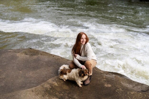 full shot smiley woman petting dog