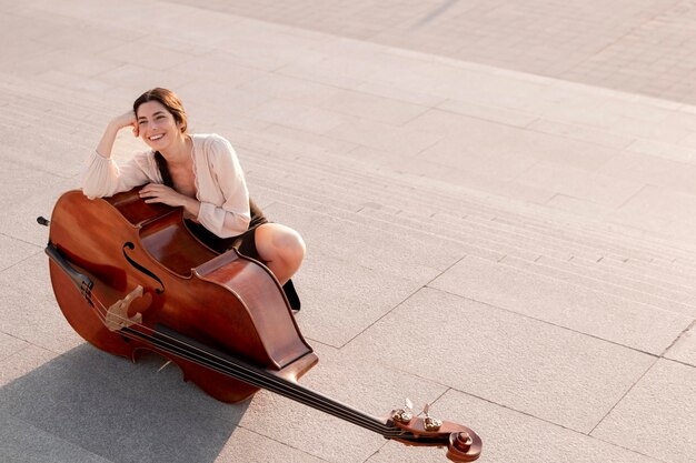 Full shot smiley woman posing with double bass