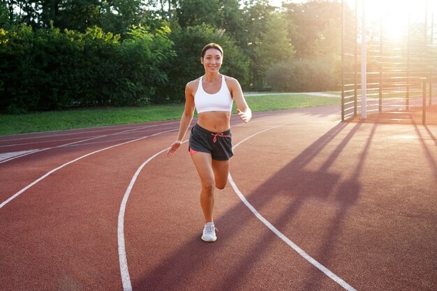 Full shot smiley woman running outdoors