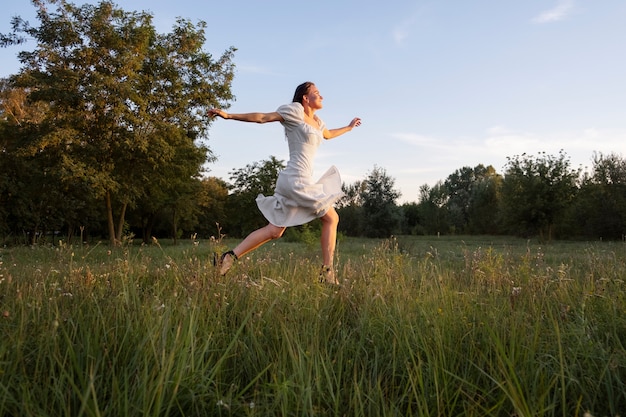 Free photo full shot smiley woman running outdoors