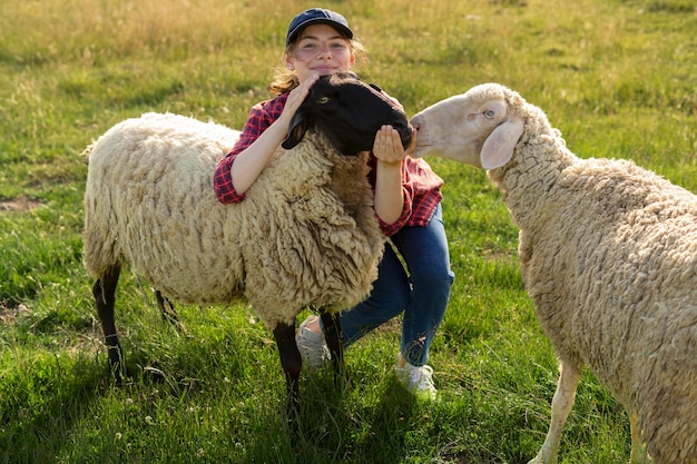 Foto gratuita donna e pecore di smiley del colpo pieno