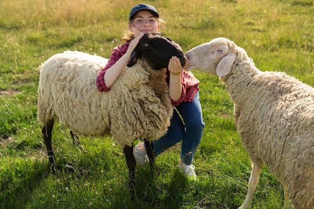 Free photo full shot smiley woman and sheep