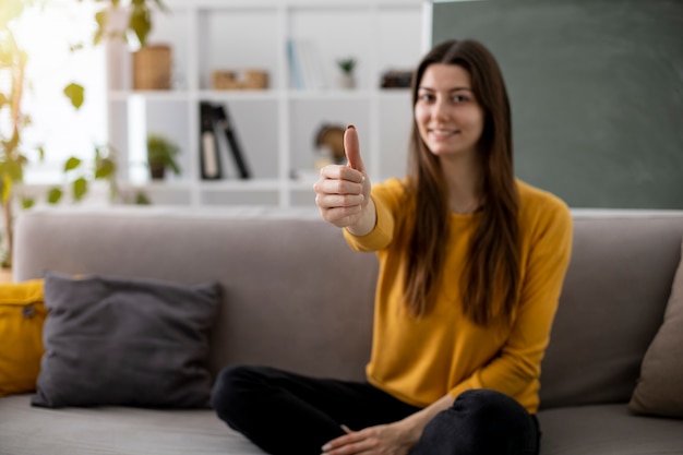 Donna sorridente del colpo pieno che mostra i pollici in su