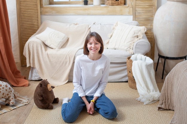 Full shot smiley woman sitting on floor