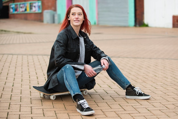 Full shot smiley woman on skateboard