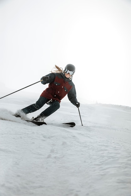 Free photo full shot smiley woman skiing outdoors