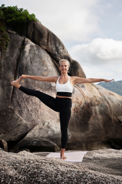 Full shot smiley woman standing on one leg