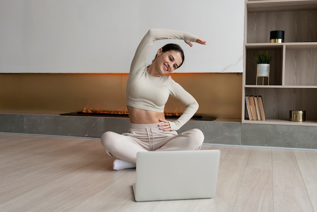 Full shot smiley woman stretching at home