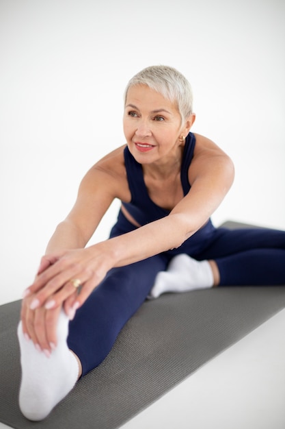 Full shot smiley woman stretching leg