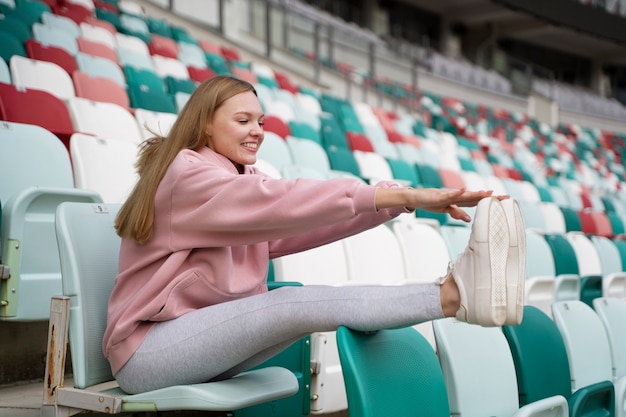 Free photo full shot smiley woman stretching