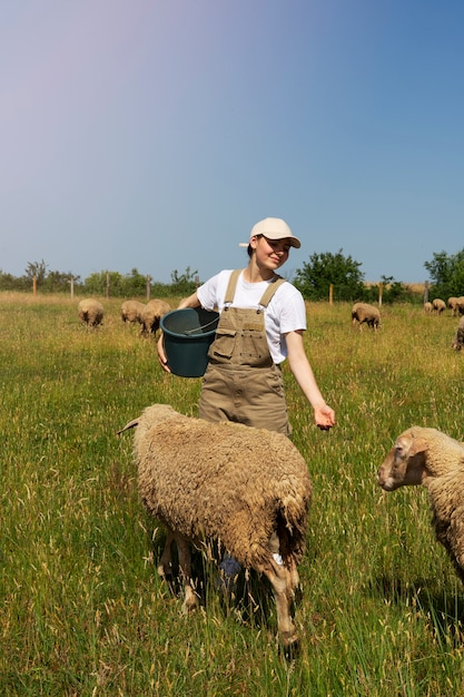 Full shot smiley woman taking care of sheep