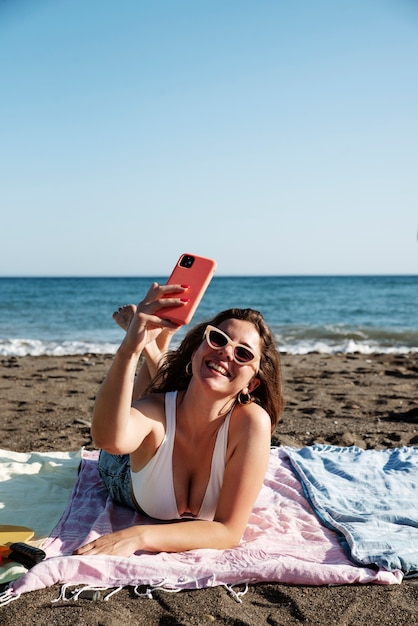 Foto gratuita donna di smiley pieno colpo prendendo selfie