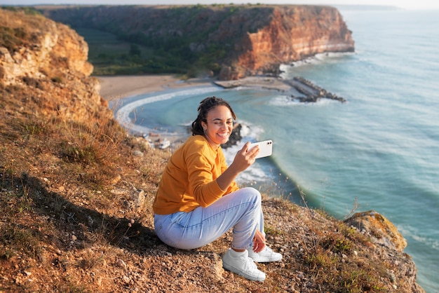 Full shot smiley woman taking selfie