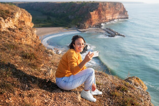 Full shot smiley woman taking selfie