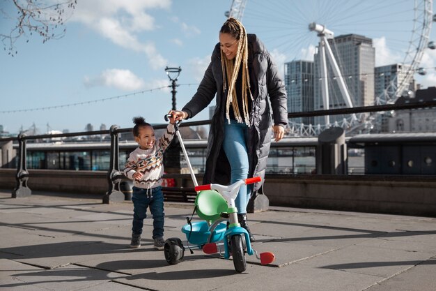 Full shot smiley woman walking with kid outdoors